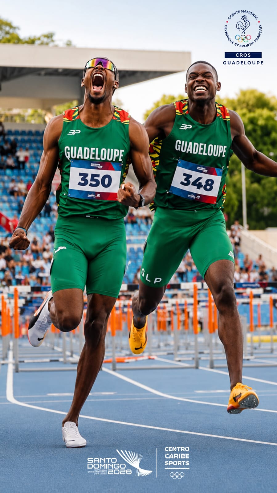 Deux athlètes en tenue verte Guadeloupe célèbrent sur une piste d’athlétisme ; les logos du visuel sont conservés.