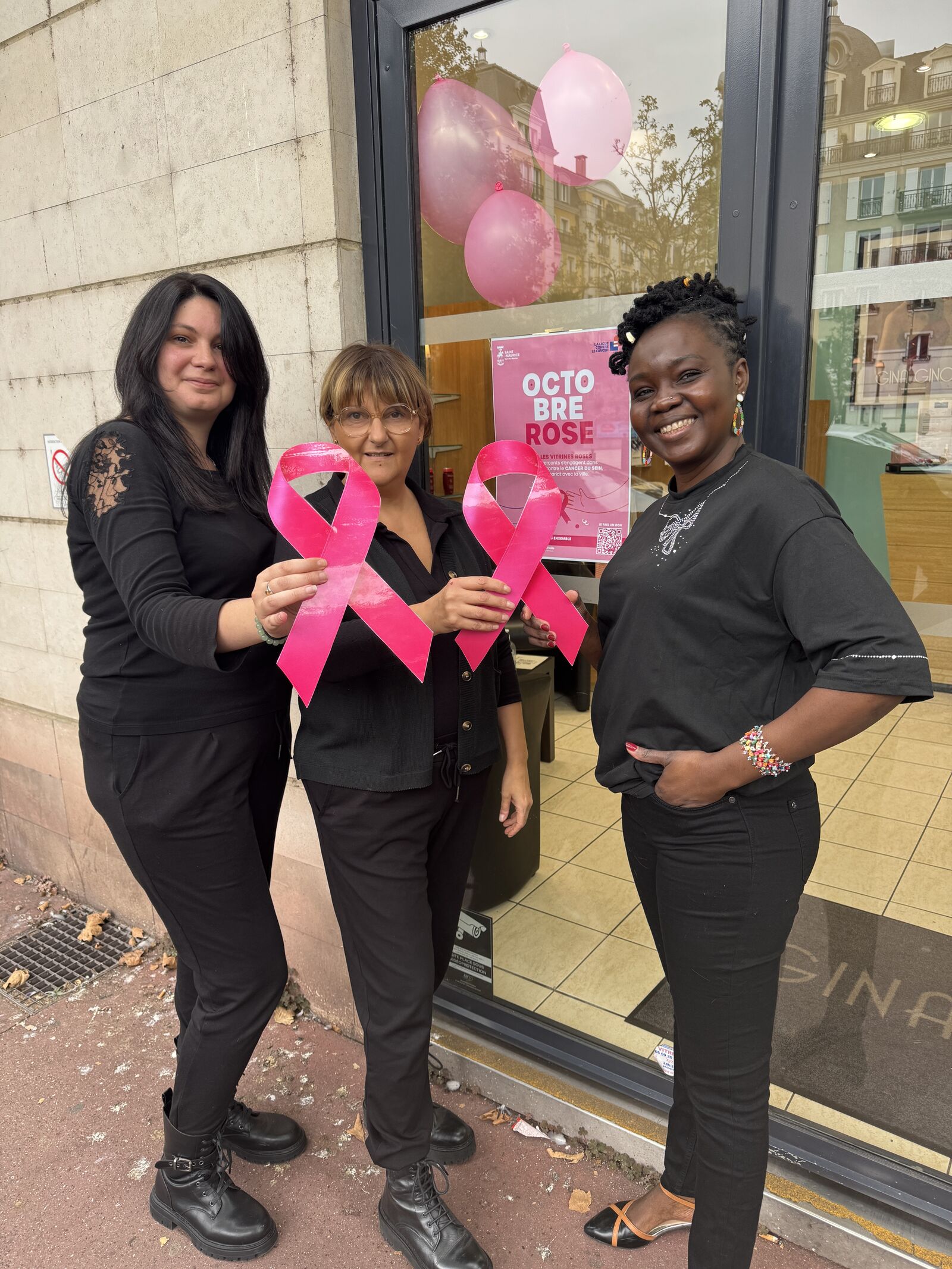 Trois femmes mobilisées pour Octobre Rose, tenant des rubans roses