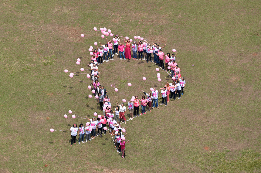 Participants formant un ruban rose collectif lors d’une action de sensibilisation